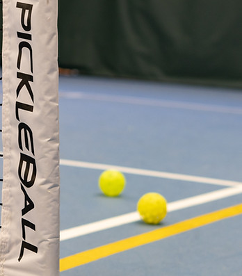 three tennis balls on a tennis court near a net_edited.jpg